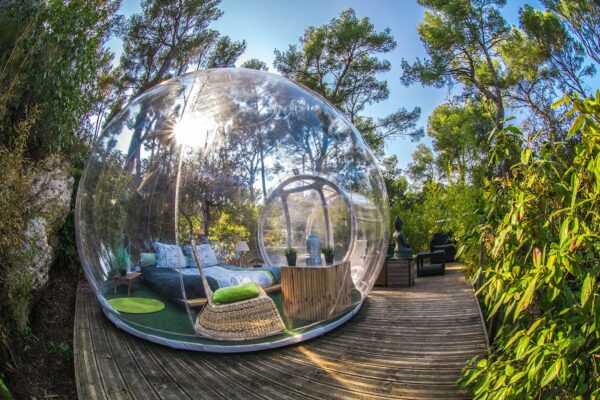 Photo extérieur bulle transparente sur terrasse. Forêt ensoleillée.