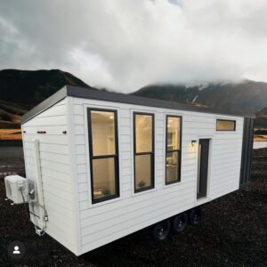 Tiny house blanche avec vu sur montagnes.