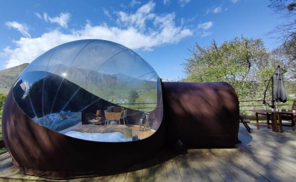 Photo coté bulle transparente. Vue sur montagne et ciel bleu.